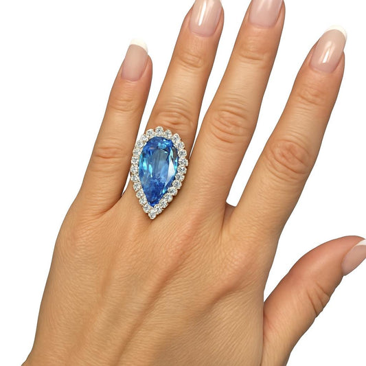 Anel de 15 quilates de topázio azul envolto em moissanite branca de 10 pontos.