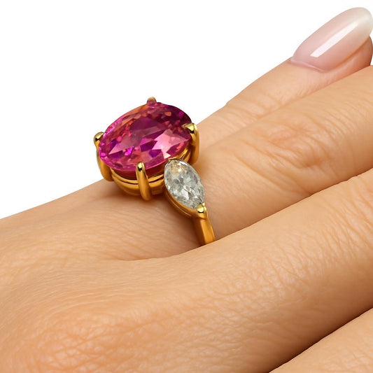 Anel em prata com banho de ouro amarelo com pedra de 5 quilates de safira rosa com duas gotas de 80 pontos nas laterais.