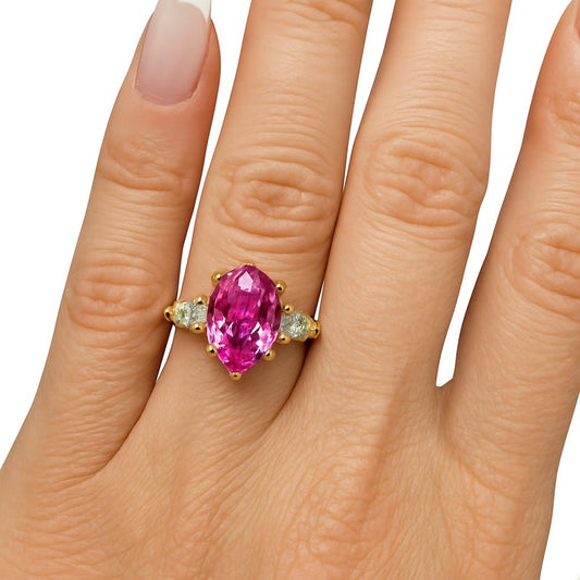 Anel em prata com banho de ouro amarelo com pedra de 5 quilates de safira rosa com duas gotas de 80 pontos nas laterais.